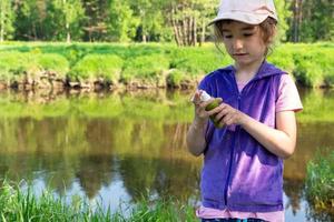 Girl sprays mosquito spray on the skin in nature that bite her hands and feet. Protection from insect bites, repellent safe for children. Outdoor recreation, against allergies. Summer time photo