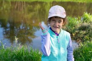 la chica rocía spray para mosquitos en la piel en la naturaleza que le muerde las manos y los pies. Protección contra picaduras de insectos, repelente seguro para niños. recreación al aire libre, contra las alergias. Hora de verano foto