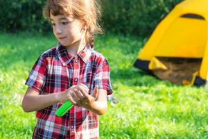 Girl sprays mosquito spray on the skin in nature that bite her hands and feet. Protection from insect bites, repellent safe for children. Outdoor recreation, against allergies. Summer time photo