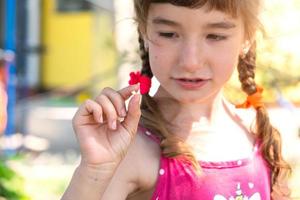 A girl holds a baby tooth that has fallen out in the palm of her hand. The child's teeth change to the molars, preschool age photo