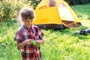 Girl sprays mosquito spray on the skin in nature that bite her hands and feet. Protection from insect bites, repellent safe for children. Outdoor recreation, against allergies. Summer time photo