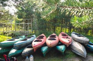 There are a lot of kayaks for a water hiking trip in a large group. Boat delivery and transportation, tourist service on a commercial trip photo