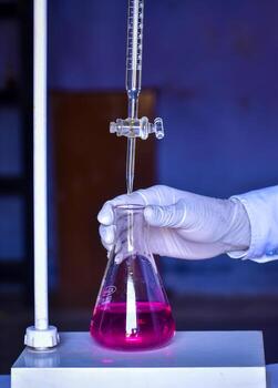 The chemist measures with precision in acid-base titration, adding solutions until neutralization photo