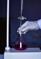 The chemist measures with precision in acid-base titration, adding solutions until neutralization photo