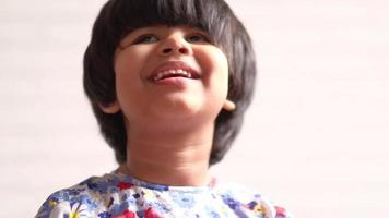 Portrait of child girl looking the camera and laughing video