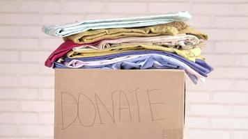 Donation box with donation clothes on a wooden table video