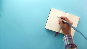 Top view of man hand writing to do list on a notebook video