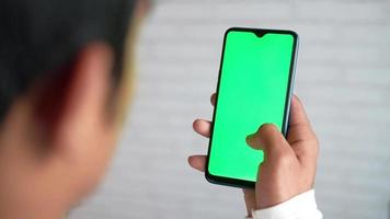 Hommes en portant intelligent téléphone avec vert écran séance video