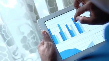 womans hand working on digital tablet with graphic video