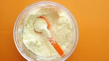 Close up of baby milk powder and spoon on tile background video