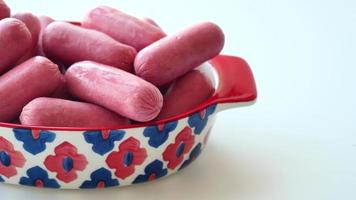 Mini Sausage in a red color bowl on white . video