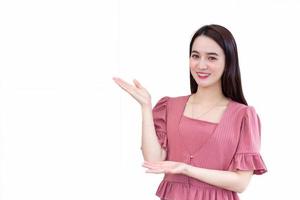 Professional beautiful Asian  business woman who wears pink dress shows hand to present something on white background. photo