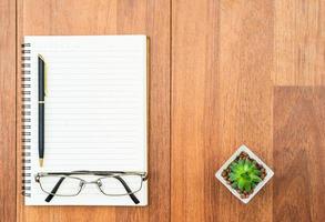 Eyeglasse and notepad on wood deck with copyspace photo