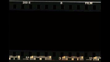 Blank old film strip frame background. Retro films border with numbers. Film scan. Digital number and bezel on film photographs scanned. 35mm film frames strip scanned with signs of usage on bezel. video