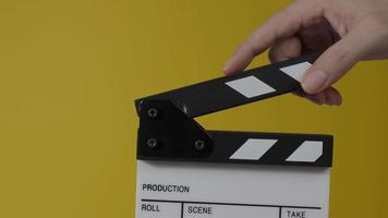 Film slate or Movie clapperboard hitting in front of cinema camera recording. Close up hand holding empty film slate and clapping it. Open and close film slate for video production. film production.
