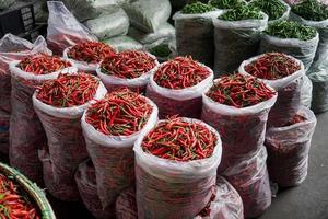 Stacks of chili peppers, packaged in plastic bags for sale in the market. photo