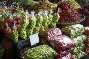 pilas de chile pimientos, empaquetado en el plastico pantalones para rebaja en el mercado. foto