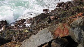 fantástica costa rochosa. ondas do mar impactam rochoso na praia video