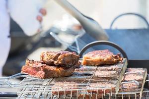 A la parrilla carne. Cocinando carne de vaca o Cerdo en el parrilla. foto