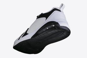 White sneaker with black accents on a black sole. Sport shoes. photo