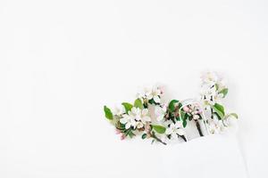 A bouquet of flowering branches of an apple tree in a shopping bag on a white background. Top view Flat lay Copy space. Spring discount concept. Seasonal sale. photo