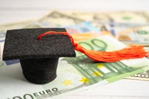 Graduation gap hat on Euro and US dollar banknotes money, Education study fee learning teach concept. photo