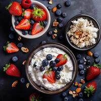 Curd cheese with fresh strawberries, blueberries, nuts and yogurt in a bowl. Healthy dairy food. Top view. . photo