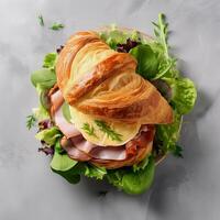 Fresh croissant sandwich with ham, cheese and salad leaf.Top view. . photo