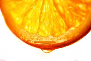 naranja rebanada con un soltar de agua cerca arriba en un blanco antecedentes foto