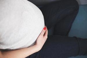 pregnant woman sitting on the sofa. pregnant belly close photo