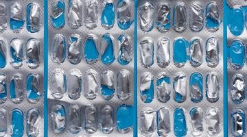 Empty blister pack of capsules on a blue background, close up photo