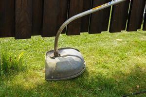 a man mows grass with a trimmer outdoor photo