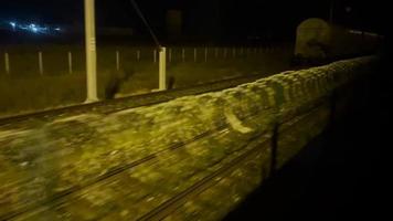 Visão a partir de janela comovente trem em Ferrovia às noite. passagem fronteira. viagem e turismo conceito video