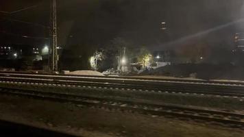 ver desde ventana Moviente tren en ferrocarril a noche. viaje y turismo concepto video