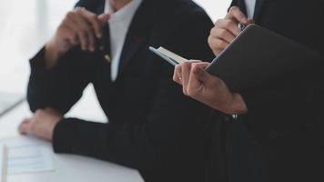 Financial analysts analyze business financial reports on a digital tablet planning investment project during a discussion at a meeting of corporate showing the results of their successful teamwork. video
