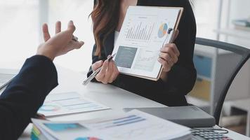 Financial analysts analyze business financial reports on a digital tablet planning investment project during a discussion at a meeting of corporate showing the results of their successful teamwork. video