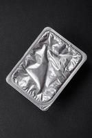 Rectangular plastic box with yogurt or cheese hermetically sealed with a foil lid photo