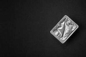 Rectangular plastic box with yogurt or cheese hermetically sealed with a foil lid photo