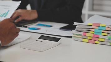 Financial analysts analyze business financial reports on a digital tablet planning investment project during a discussion at a meeting of corporate showing the results of their successful teamwork. video