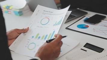 Financial analysts analyze business financial reports on a digital tablet planning investment project during a discussion at a meeting of corporate showing the results of their successful teamwork. video