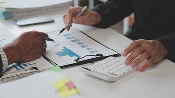 Financial analysts analyze business financial reports on a digital tablet planning investment project during a discussion at a meeting of corporate showing the results of their successful teamwork. video