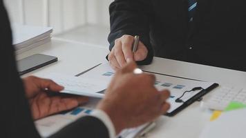 Financial analysts analyze business financial reports on a digital tablet planning investment project during a discussion at a meeting of corporate showing the results of their successful teamwork. video