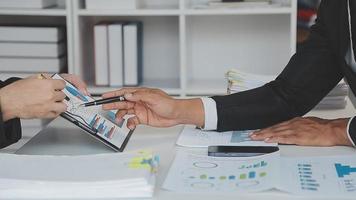 Financial analysts analyze business financial reports on a digital tablet planning investment project during a discussion at a meeting of corporate showing the results of their successful teamwork. video