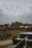 background glass pane in drops of water with a view of the spanish stone photo