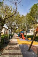 vacío callejón con arboles en un pequeño Español pueblo en un primavera día foto