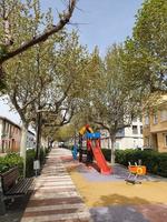 vacío callejón con arboles en un pequeño Español pueblo en un primavera día foto