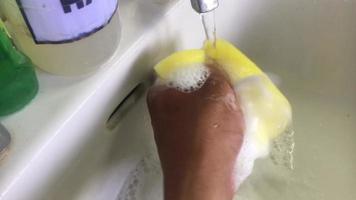 maschio mani risciacquato il Lavello utilizzando sapone e un' acqua spugna. fare compiti a casa. routine lavaggio, statico telecamera. video