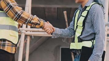 Two Specialists Inspect Commercial, Industrial Building Construction Site. Real Estate Project with Civil Engineer, Investor Use Laptop. In the Background Crane, Skyscraper Concrete Formwork Frames video