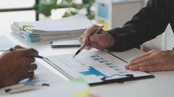 Financial analysts analyze business financial reports on a digital tablet planning investment project during a discussion at a meeting of corporate showing the results of their successful teamwork. video