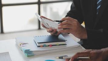 Financial analysts analyze business financial reports on a digital tablet planning investment project during a discussion at a meeting of corporate showing the results of their successful teamwork. video